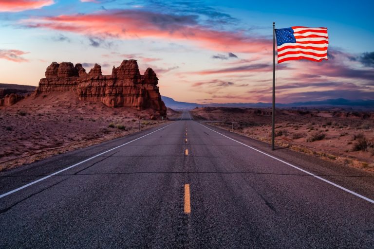 Scenic road in the desert with American flag